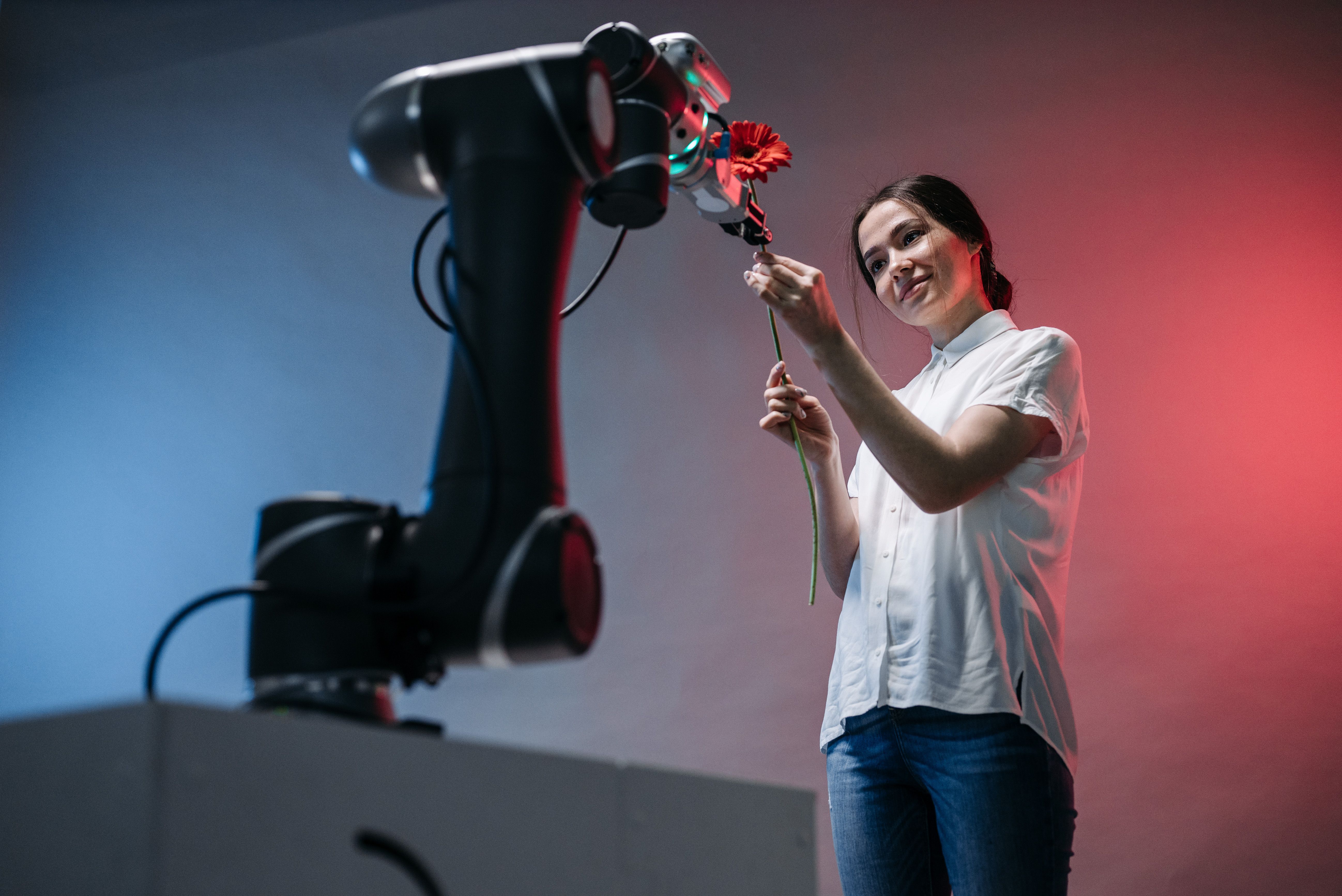 Woman and robot arm collaboratively holding a flower, illustrating AI-powered gardening advice